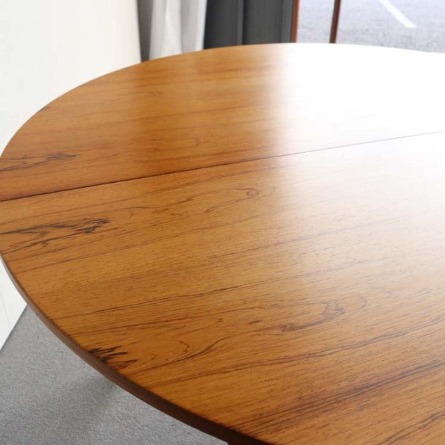 Round vintage teak dining table by McIntosh with rich wood grain and mid-century British design.