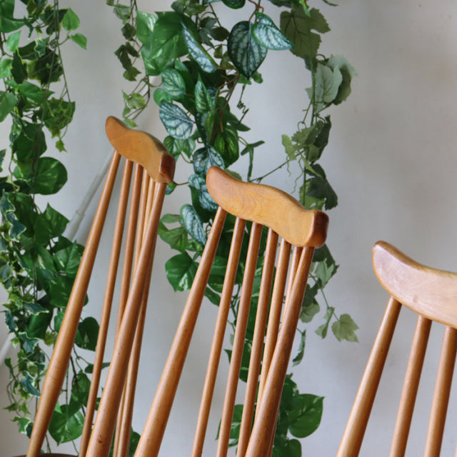 Set of four British mid-century vintage Ercol Goldsmith highback dining chairs in natural teak with slender tapered legs and .