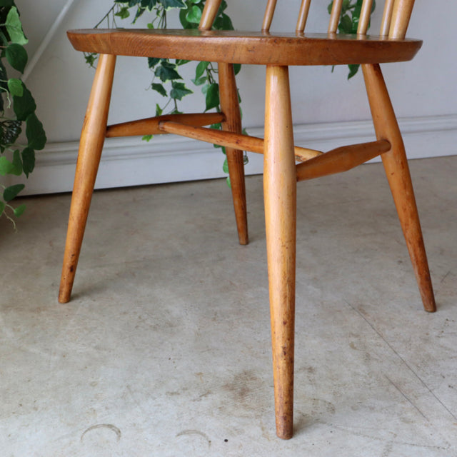 Mid-century British Ercol Goldsmith teak high-back chair with tapered legs and visible wood grain in natural color.