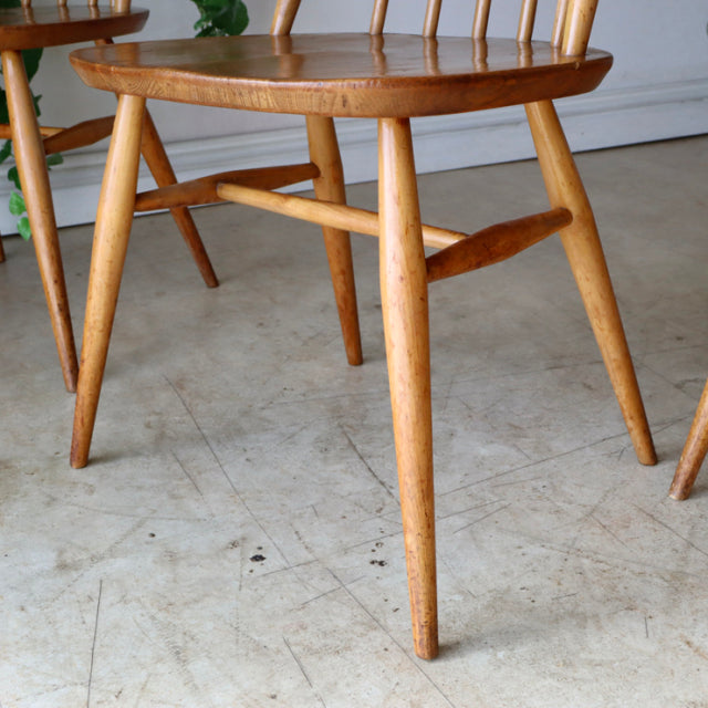 Set of four vintage Arcol Goldsmith mid-century teak dining chairs in natural finish with tapered legs and curved spindle.