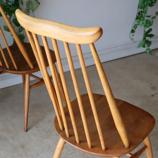 Set of four vintage Ercol Goldsmith high-back dining chairs in natural teak with smooth curved top rails and slender.