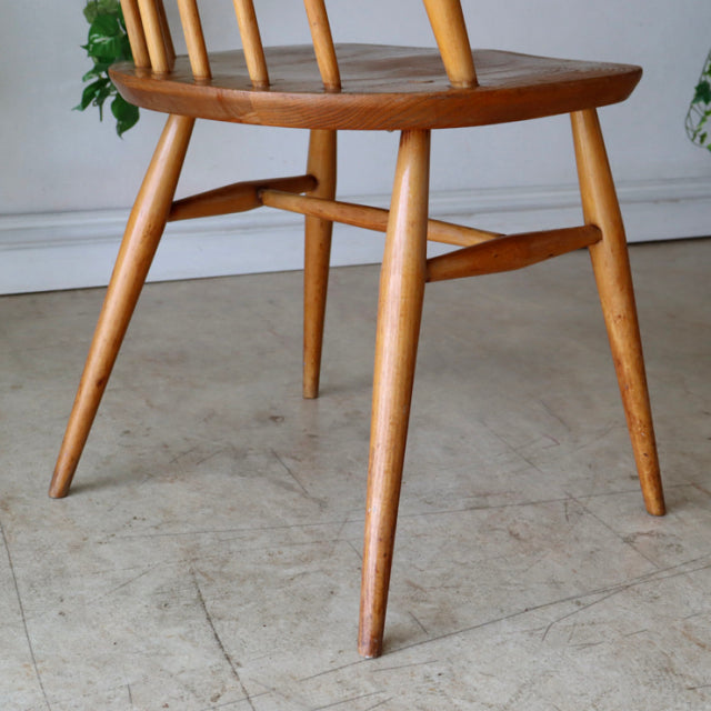 Mid-century British Ercol Goldsmith teak dining chair in natural color with slender spindle back and angled legs, set of.