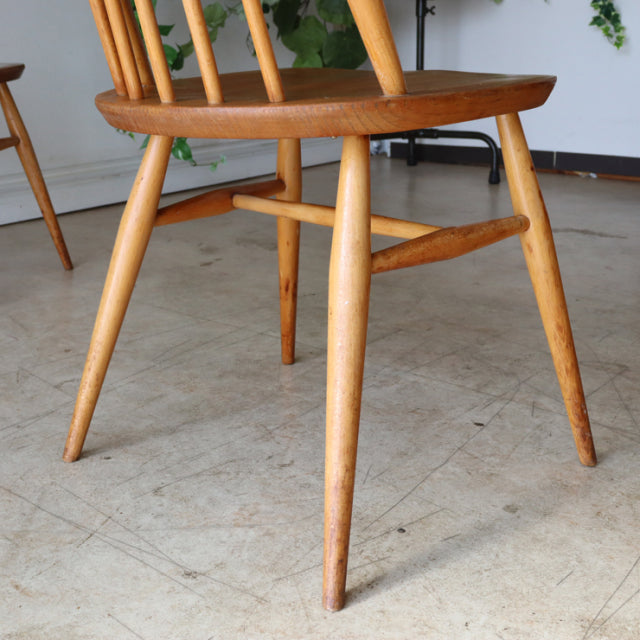 Set of four vintage British Ercol Goldsmith mid-century dining chairs in natural teak with spindle backs and tapered legs,.