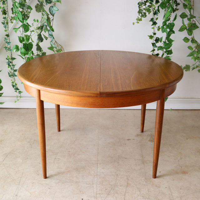 Vintage British G-Plan teak mid-century dining table with round top and tapered legs, Danish style.