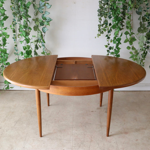 Vintage teak G-Plan British mid-century dining table with oval shape and tapered legs from Denmark.