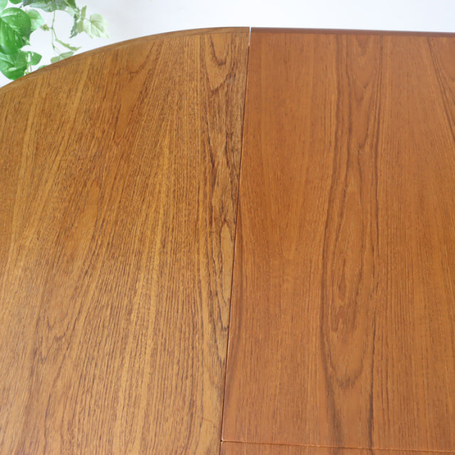 Vintage British mid-century teak G-Plan dining table top with rich wood grain and warm tones.