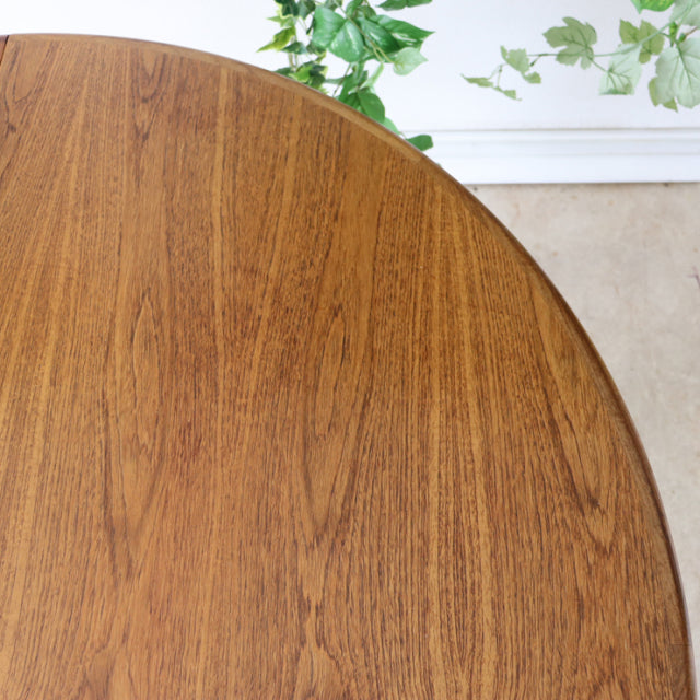 Vintage teak G-Plan mid-century British dining table with smooth oval top and rich wood grain.