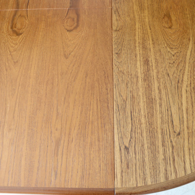 Vintage teak G-Plan British mid-century dining table top showing warm wood grain and smooth oval edge.