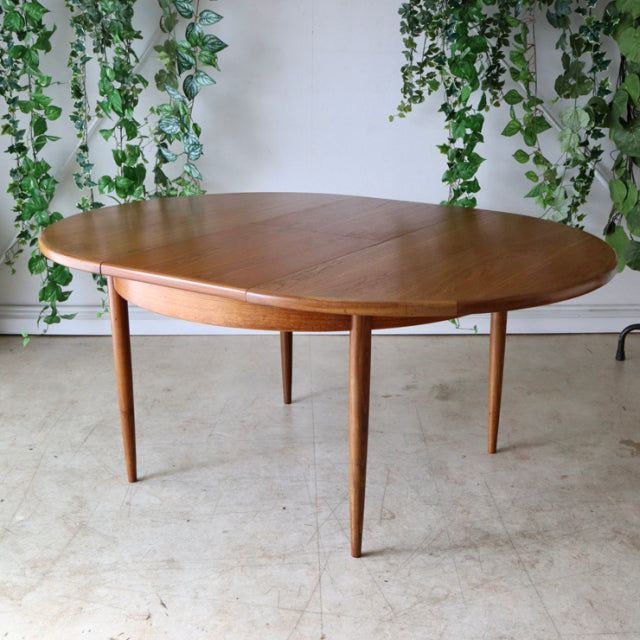 Vintage teak G-Plan mid-century dining table with rounded edges and slender tapered British-style legs.