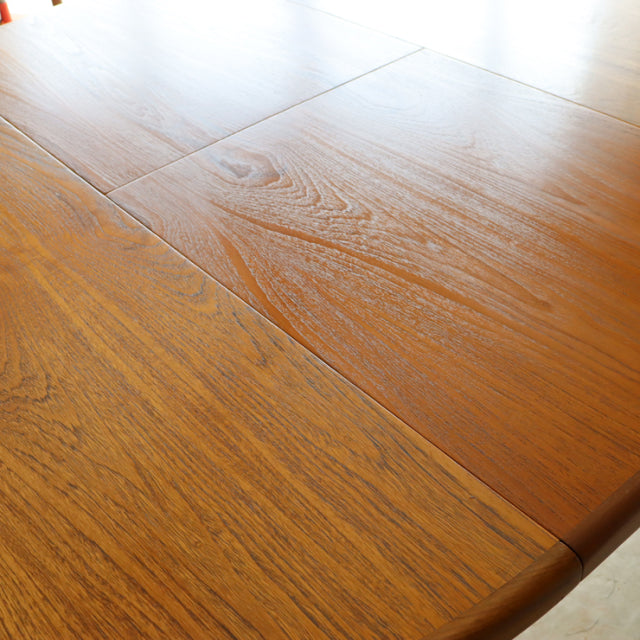 Mid-century British G-Plan dining table in vintage teak with smooth oval top and visible wood grain.