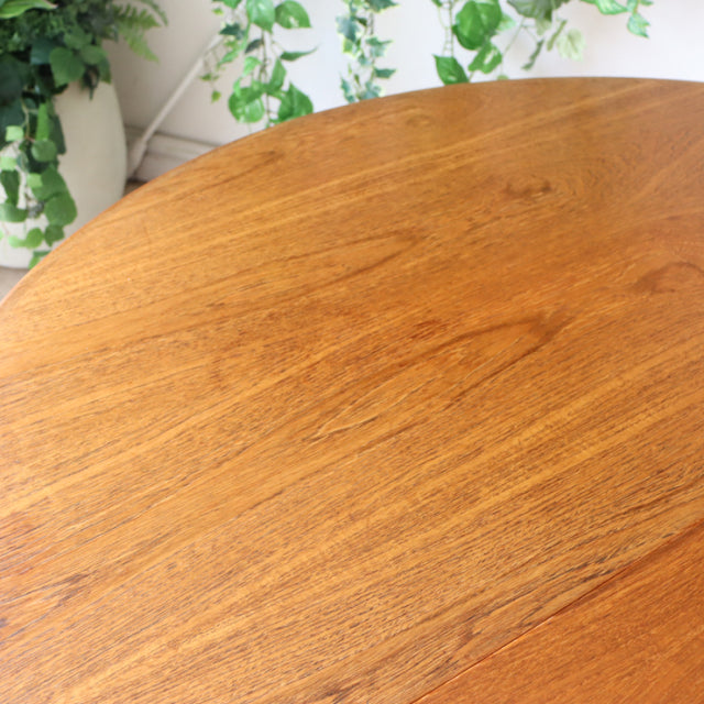 Vintage British G-Plan mid-century teak dining table with smooth oval top and rich wood grain.