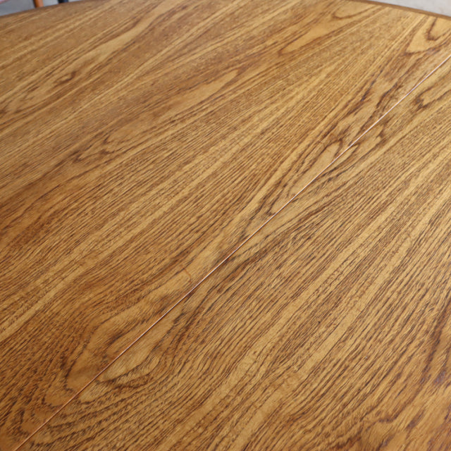 Close-up of vintage British G-Plan teak dining table top showing rich wood grain and smooth finish.