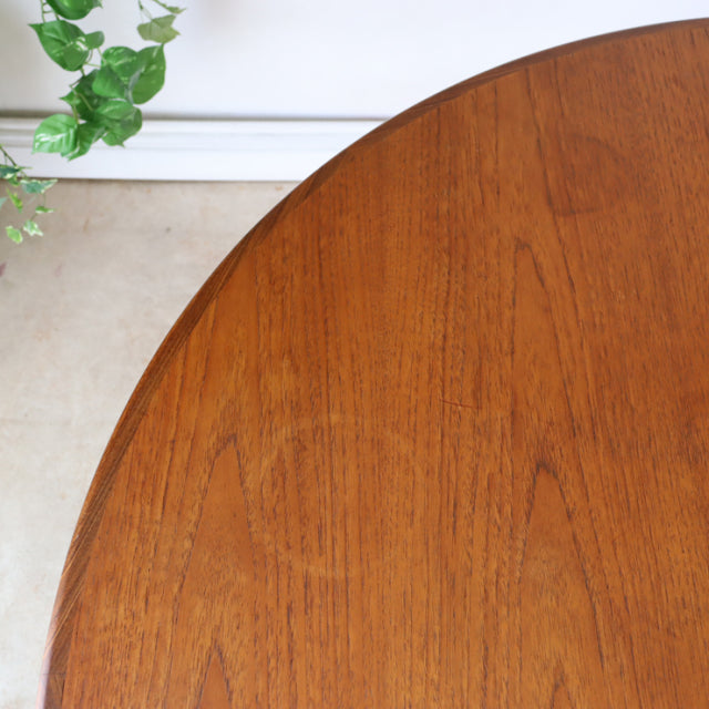 Vintage mid-century British G-Plan teak round dining table with rich wood grain and tapered legs.