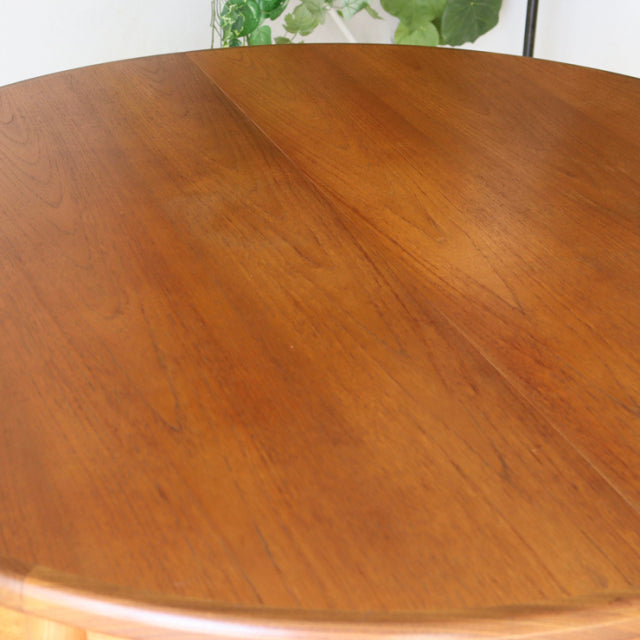 Vintage teak round dining table by British G-Plan featuring smooth wood grain and tapered mid-century legs.