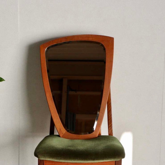 Mid-century Danish vintage teak wall mirror with organic kidney-shaped frame above British mid-century green velvet.