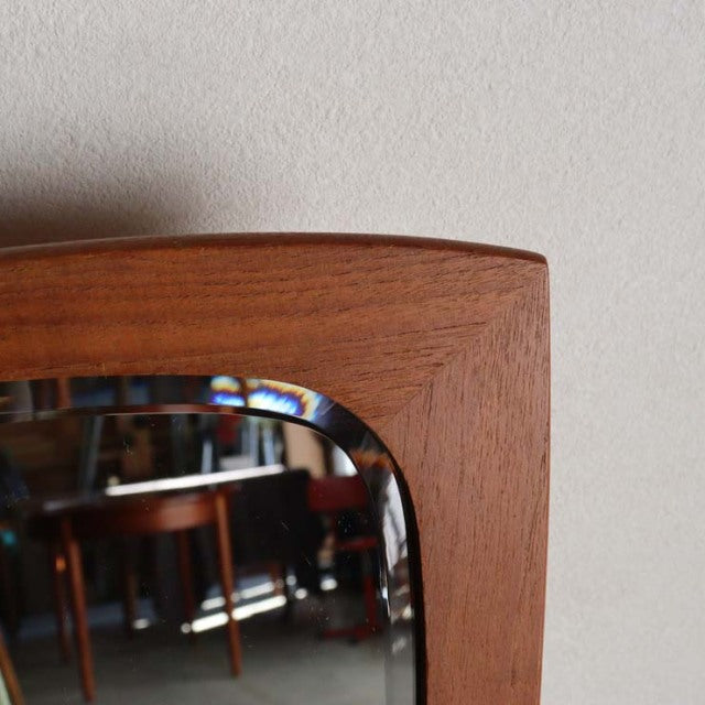 Vintage mid-century teak wall mirror with smooth rounded corners, showcasing rich wood grain, Danish design.