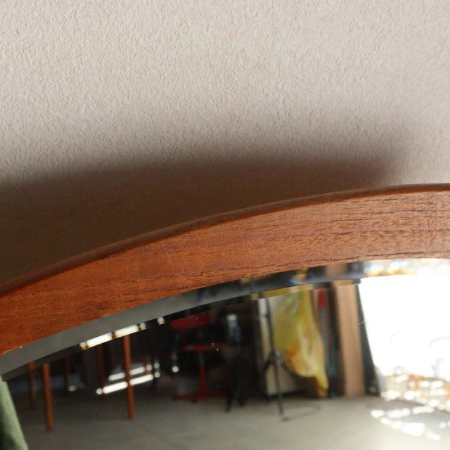 Vintage mid-century teak wall mirror with smooth rounded edges and visible wood grain, showcasing Danish craftsmanship from.