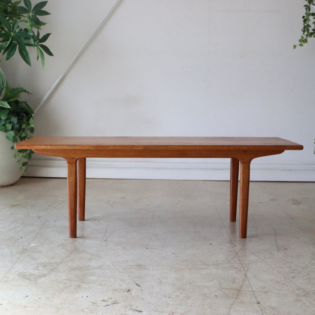 Mid-century British vintage teak coffee table with smooth wood grain, tapered legs, and minimalist rectangular design.