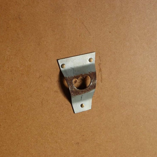 Close-up of vintage teak mirror back bracket with metal mounting plate, showcasing mid-century Danish craftsmanship.