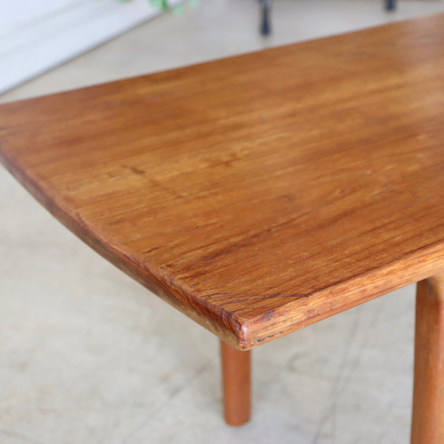 Vintage teak coffee table with rich wood grain, rounded edges, and slender mid-century British legs.