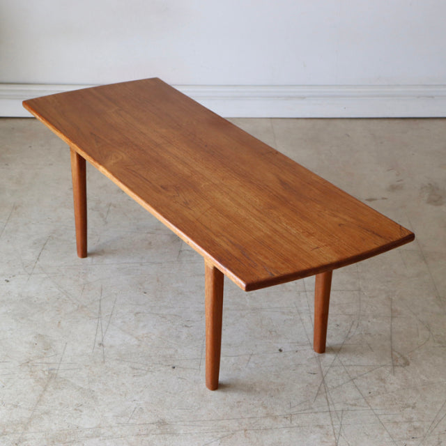 Mid-century vintage teak coffee table with smooth wood grain and tapered round legs, British-Denmark style.