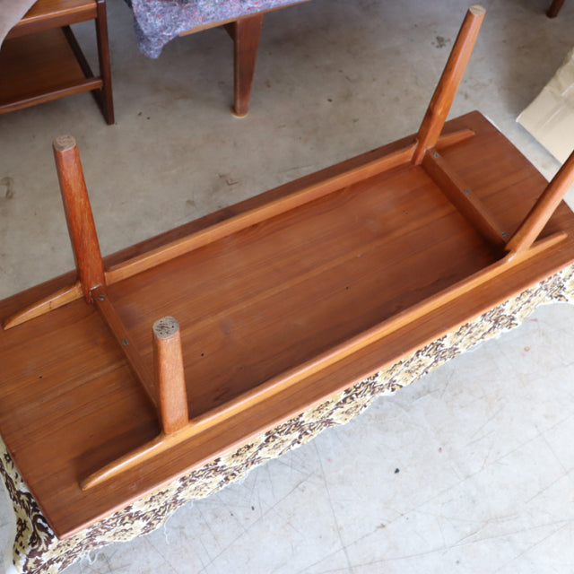 Mid-century British vintage teak coffee table with rich wood grain and tapered legs shown upside down.