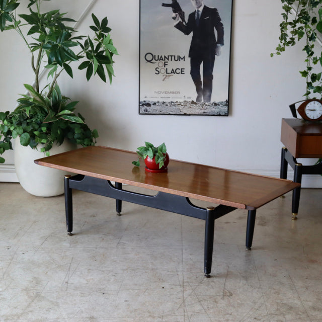 Mid-century British G-Plan teak coffee table with sleek black tapered legs and visible wood grain finish.