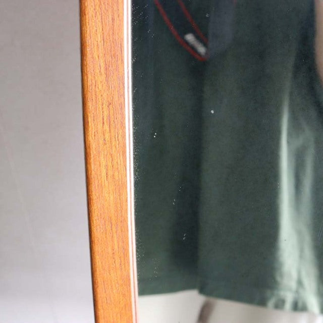 Mid-century British vintage teak wall mirror with warm wood grain and slim rectangular frame.