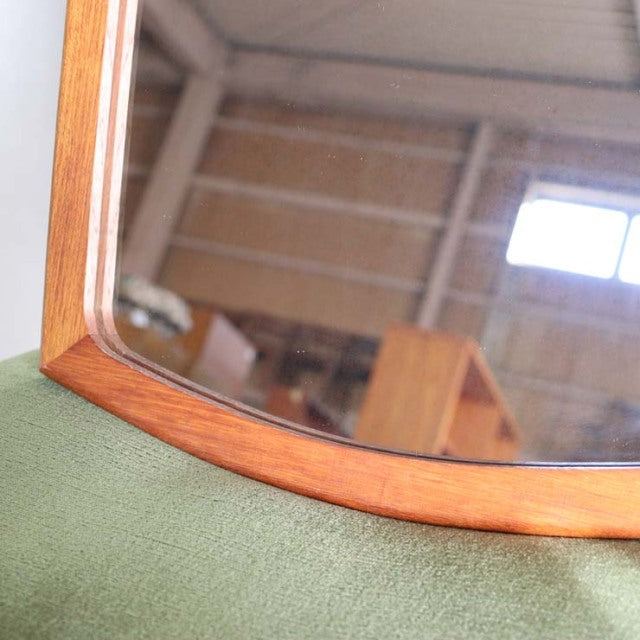 Mid-century British vintage teak mirror with smooth rounded edges and visible wood grain.