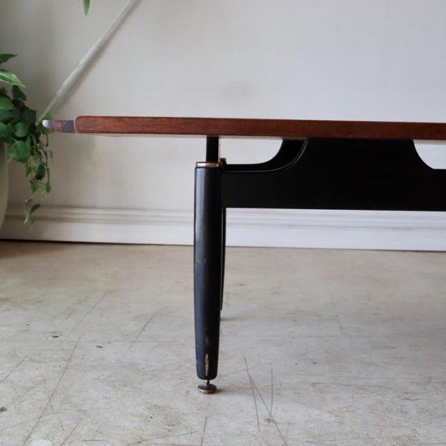 Mid-century British G-PLAN teak coffee table with sleek black tapered legs and visible wood grain top.
