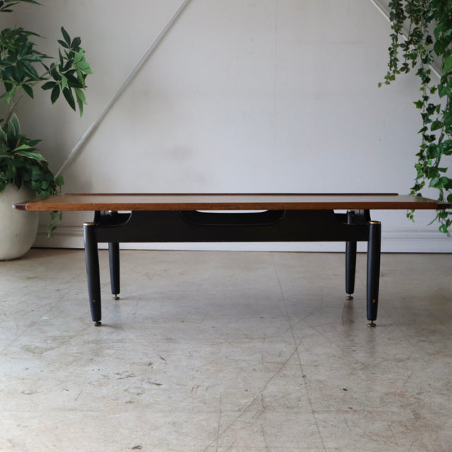 Mid-century British teak coffee table by G-Plan with sleek black legs and visible wood grain.