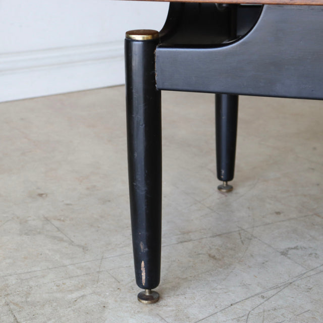 Black tapered wooden leg with brass foot of vintage mid-century British teak G-Plan coffee table.