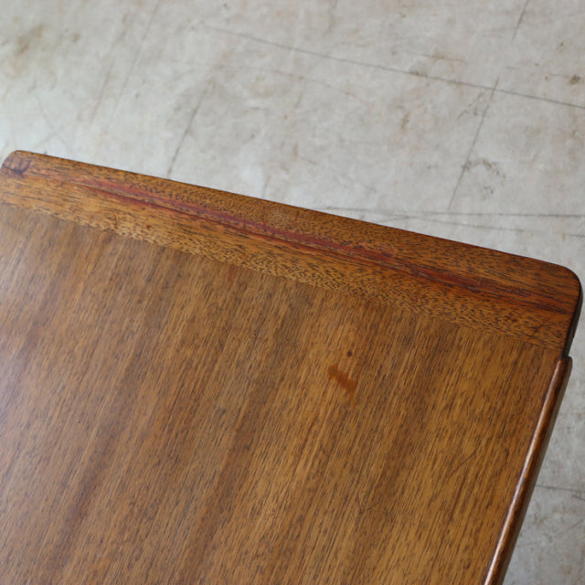 Vintage British mid-century teak G-Plan coffee table corner with rich wood grain and rounded edges.