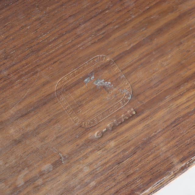 Close-up of vintage British G-Plan teak coffee table surface showing mid-century wood grain and worn finish with small.