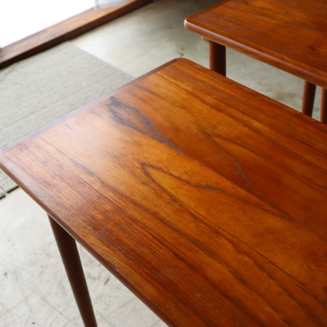 Set of vintage mid-century Danish teak nest tables with smooth wood grain and tapered legs, showcasing British and.