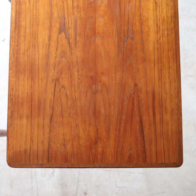 Vintage mid-century Danish teak nest table top with warm wood grain and smooth edges.