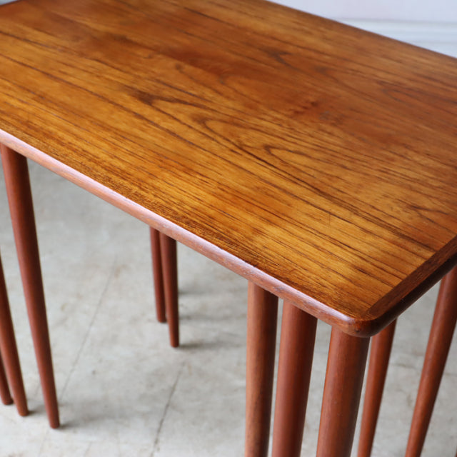 Vintage mid-century Danish teak nest tables with rich wood grain and slender tapered legs.