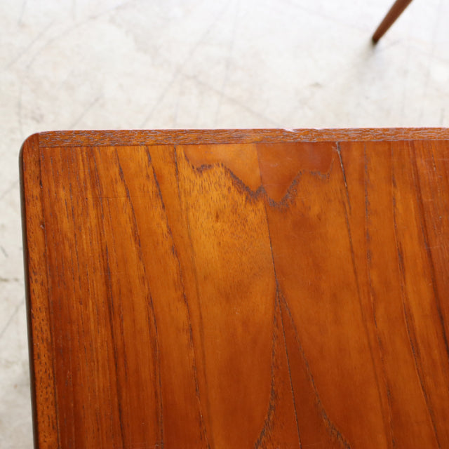 Vintage teak nest table corner showing rich wood grain and smooth finish typical of mid-century Danish design.