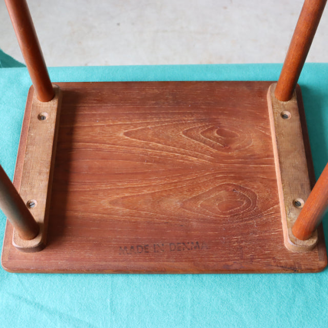 Vintage mid-century Danish teak nest table base showing rich wood grain and sturdy turned legs with engraved maker’s mark at .