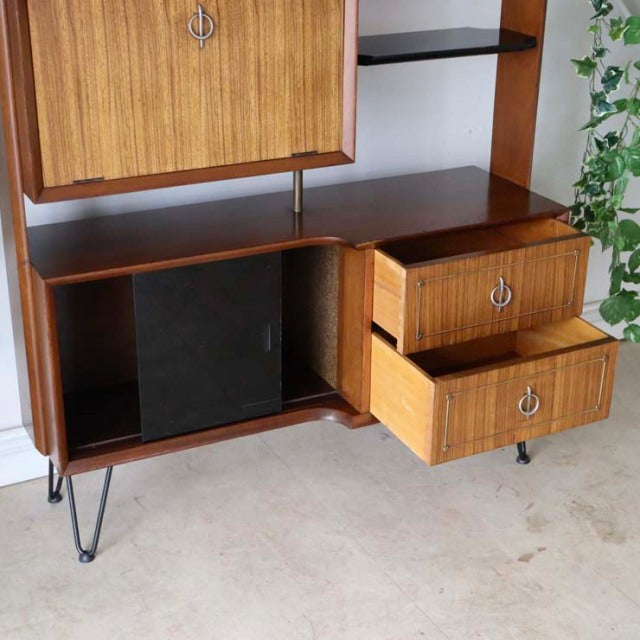 Vintage teak mid-century British room divider with iron legs, wood grain cabinet and drawers, Danish-inspired design.