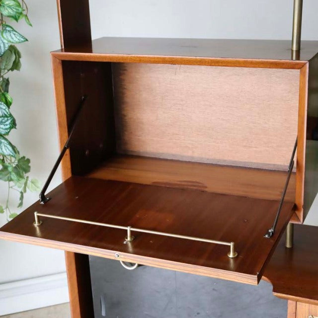 Mid-century British vintage teak room divider with iron legs, rich wood grain, and fold-down cabinet door with brass rail.