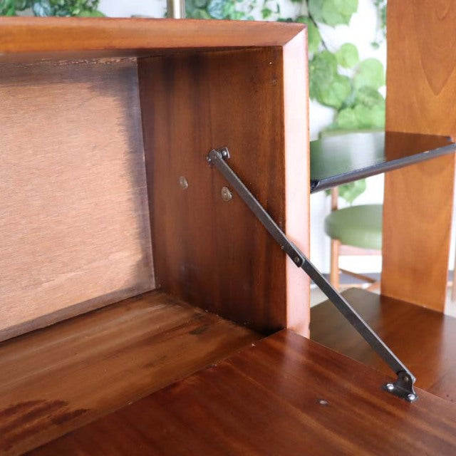 Close-up of vintage teak mid-century British room divider with iron leg support and rich wood grain finish.