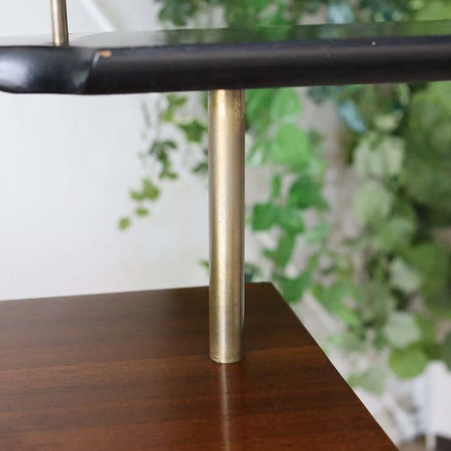 Close-up of mid-century vintage teak wood furniture corner with smooth grain and brass iron leg, British-Denmark design.