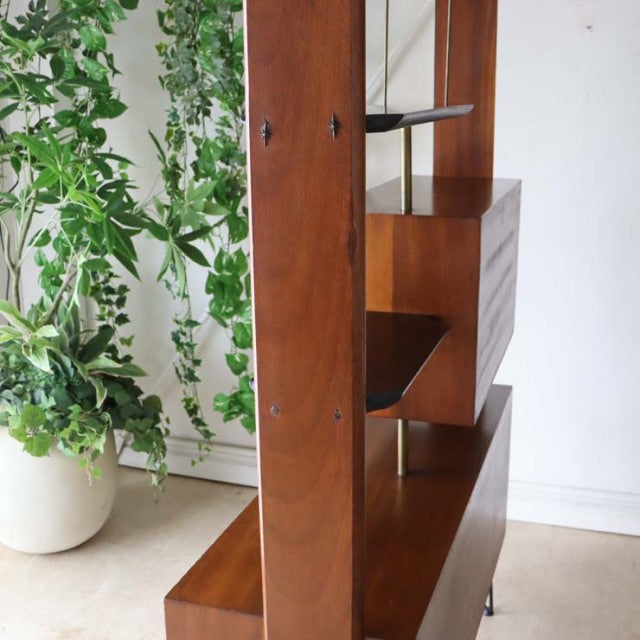 Vintage mid-century teak room divider with British design influences, featuring iron legs and rich wood grain visible on.