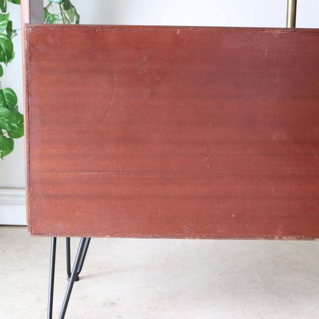 Vintage teak mid-century British room divider with smooth wood grain and slender iron legs.