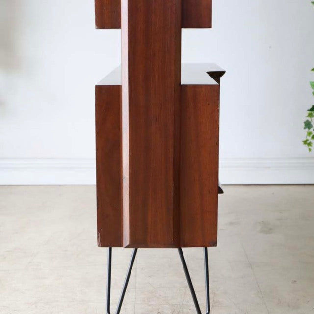 Vintage teak mid-century room divider with British design, iron hairpin legs, and rich wood grain.