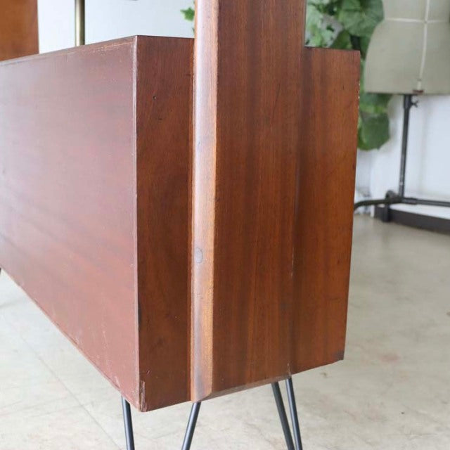 Mid-century British vintage teak room divider with rich wood grain and slender iron legs.
