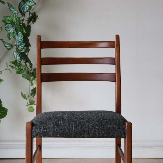 Vintage mid-century teak dining chair with dark upholstered seat, British design, straight horizontal slat back, and tapered .