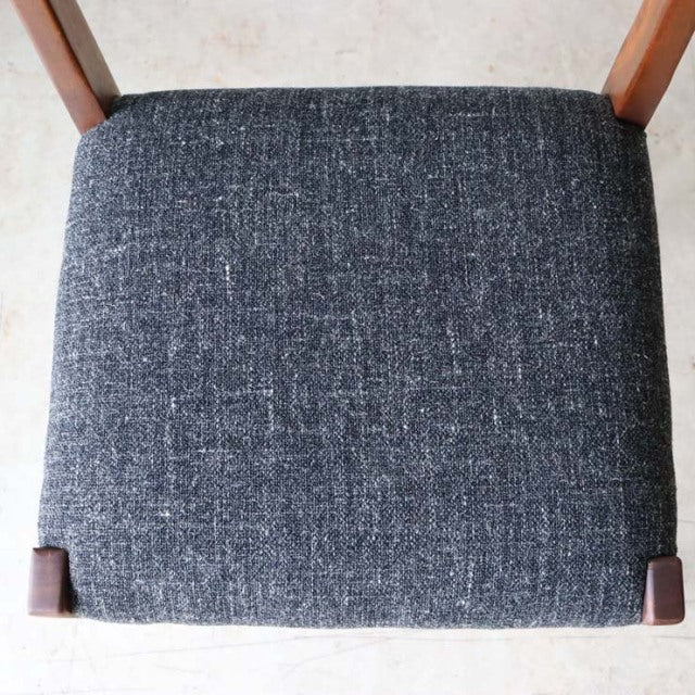 Mid-century British vintage teak dining chair seat with dark textured fabric upholstery and visible wood grain edges.