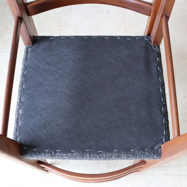 Vintage teak British mid-century dining chair seat with black reupholstered cushion and curved wooden frame.